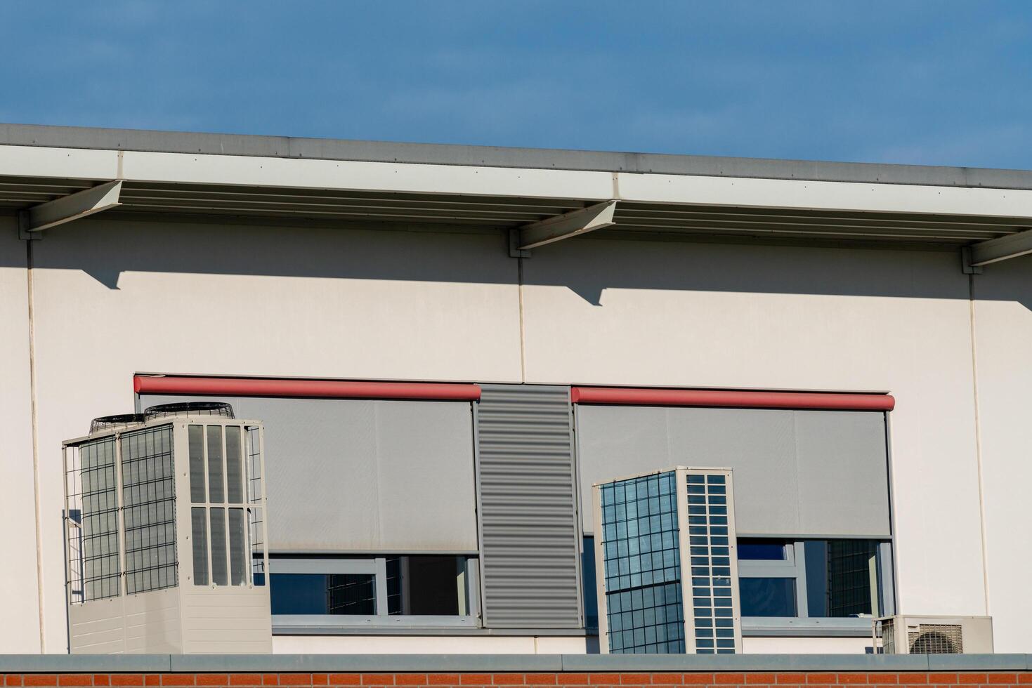 Modern building facade with window shades and ventilation units photo