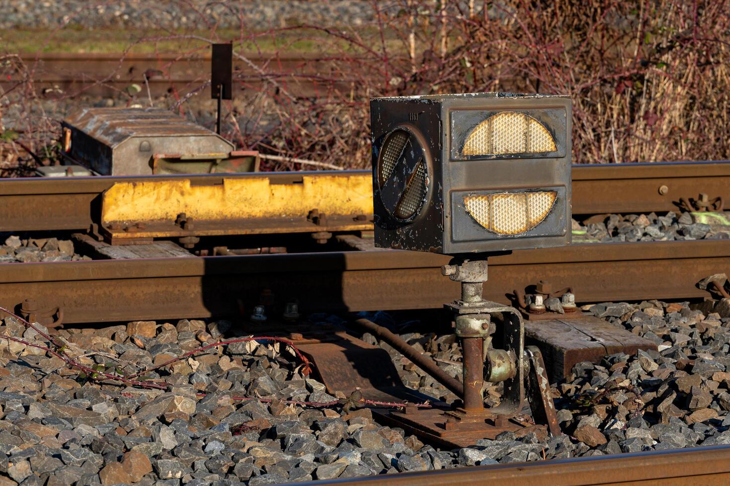 Railway signal control near train tracks during daylight photo