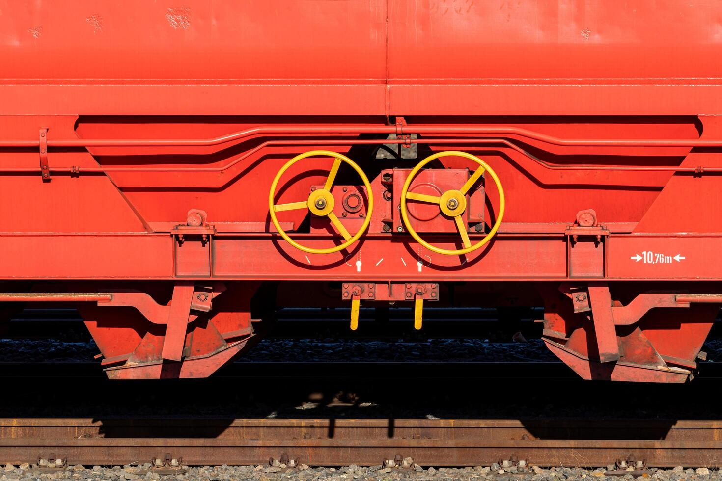 Detailed view of equipment on a red freight train car at a rail yard photo