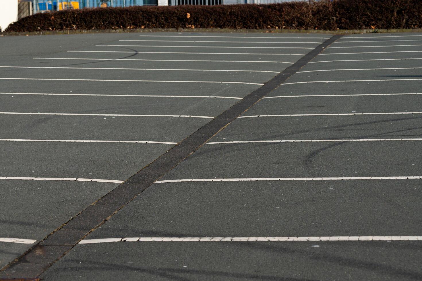 Parking lot with empty spaces and clear lines during daylight photo