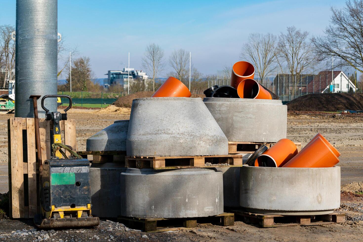 Construction site with concrete pipes and pallets in a sunny setting photo
