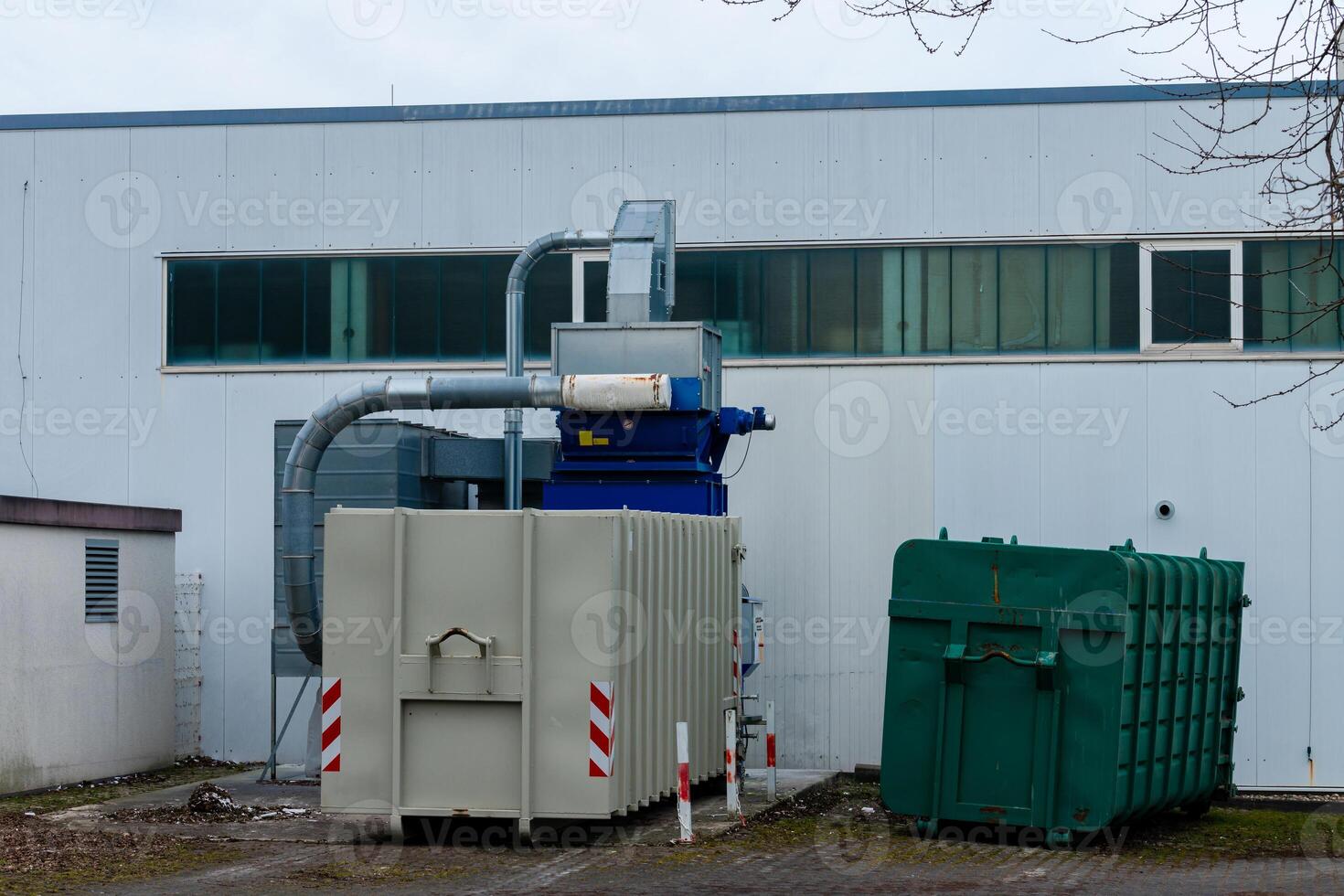 Industrial machinery working behind a factory building photo