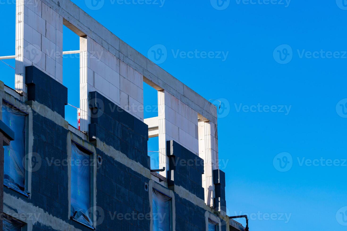 Unfinished wall of a building made of cement blocks under a blue sky photo