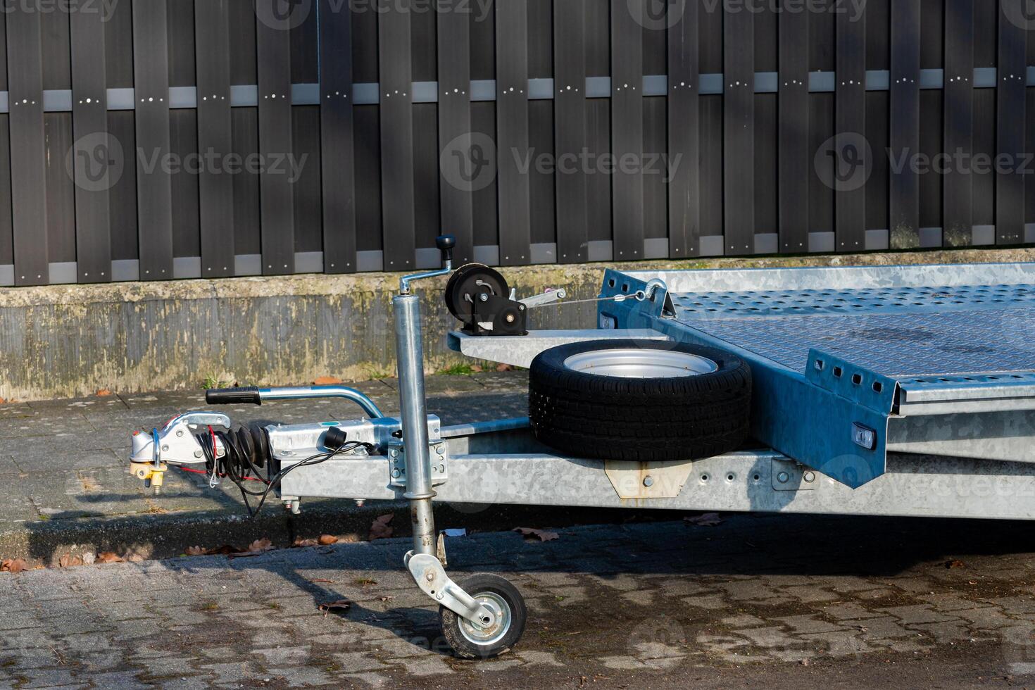 Car trailer on display with single tire resting beside it photo