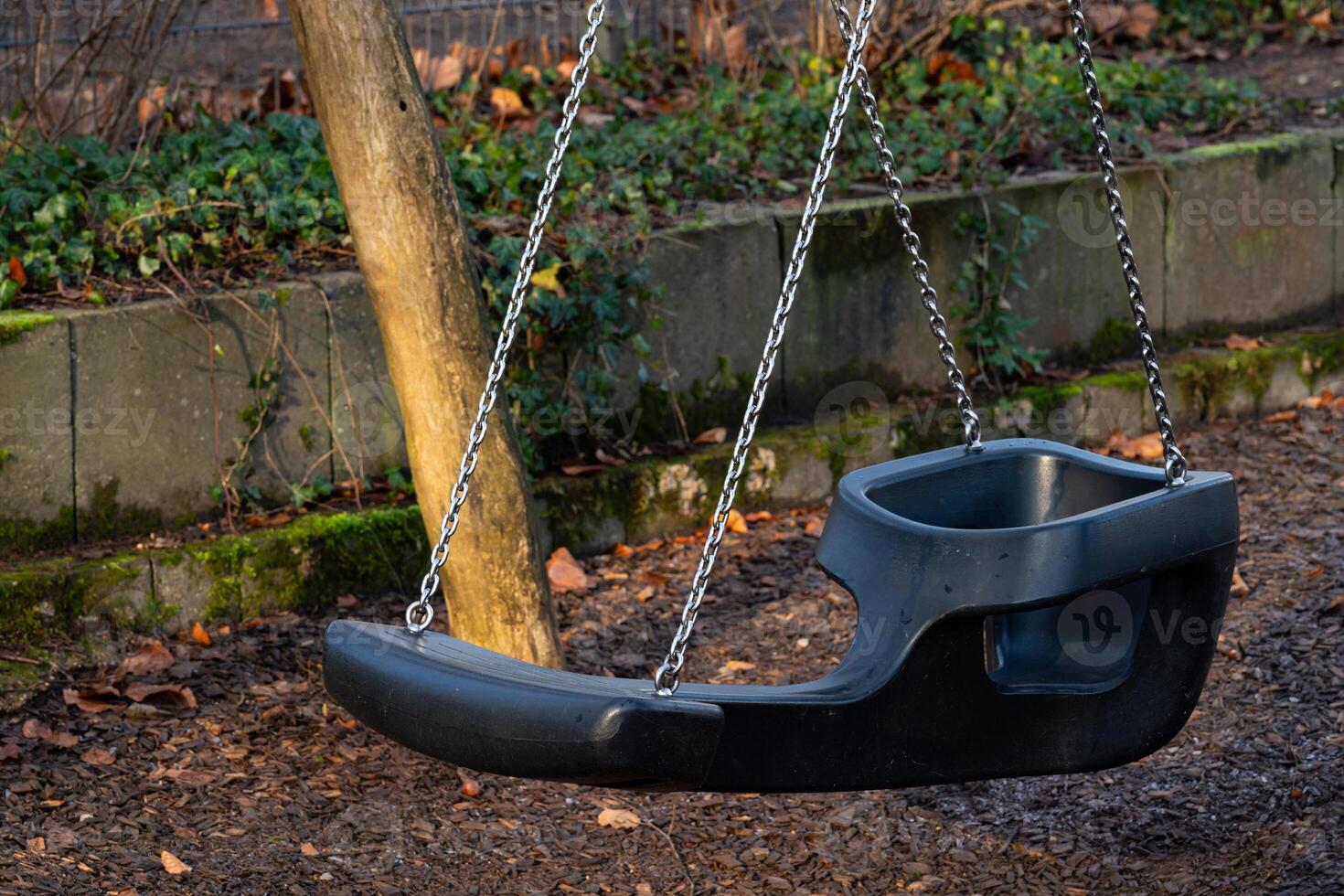 Swing set empty in a peaceful park during afternoon light photo