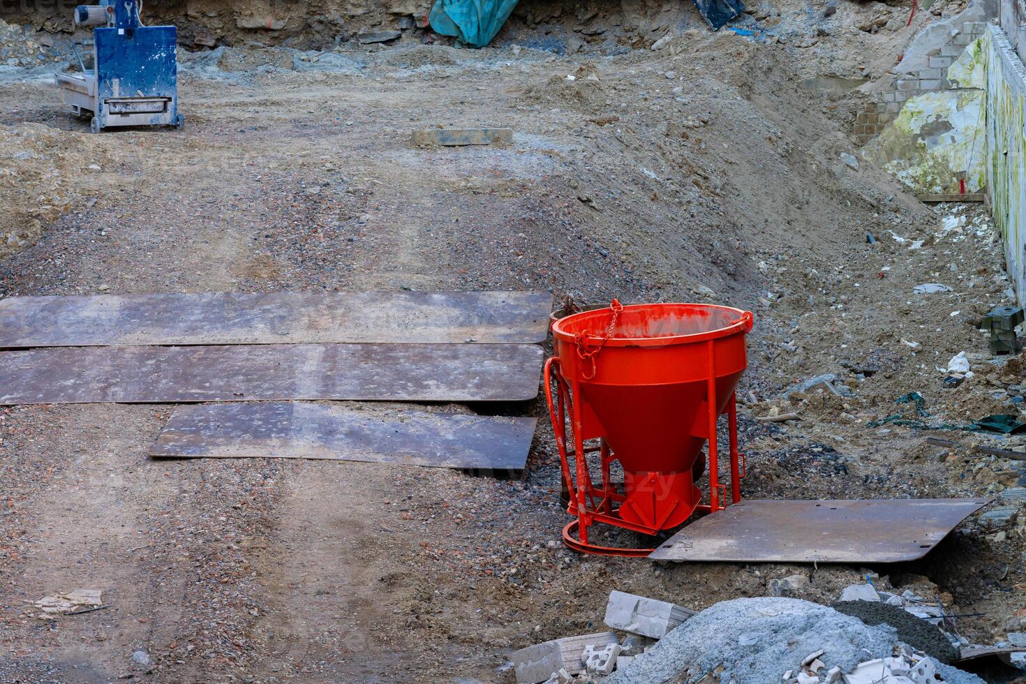 Construction site with orange mixer and materials during daylight photo