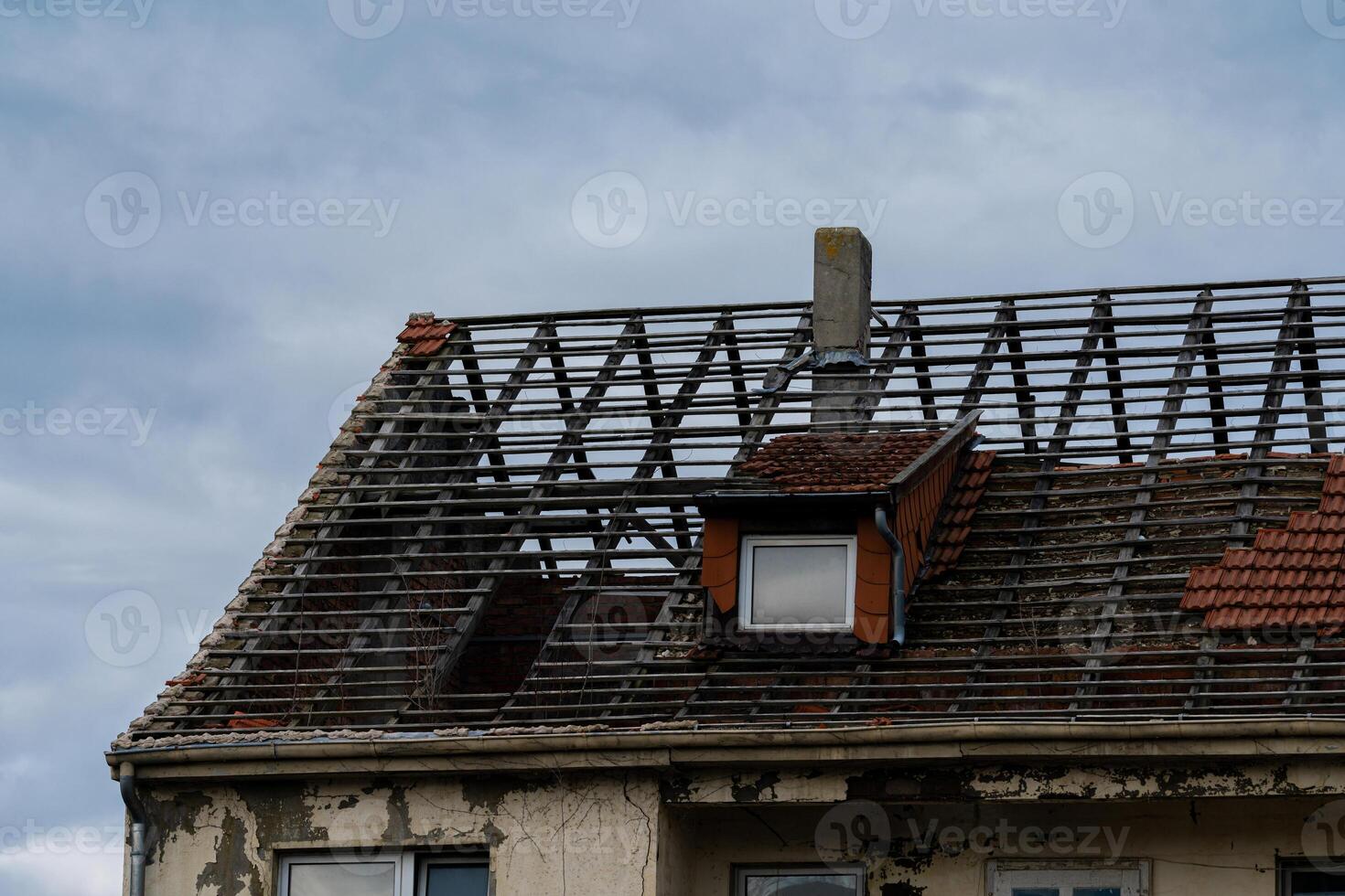 Roof renovation in progress on an old building under cloudy sky photo