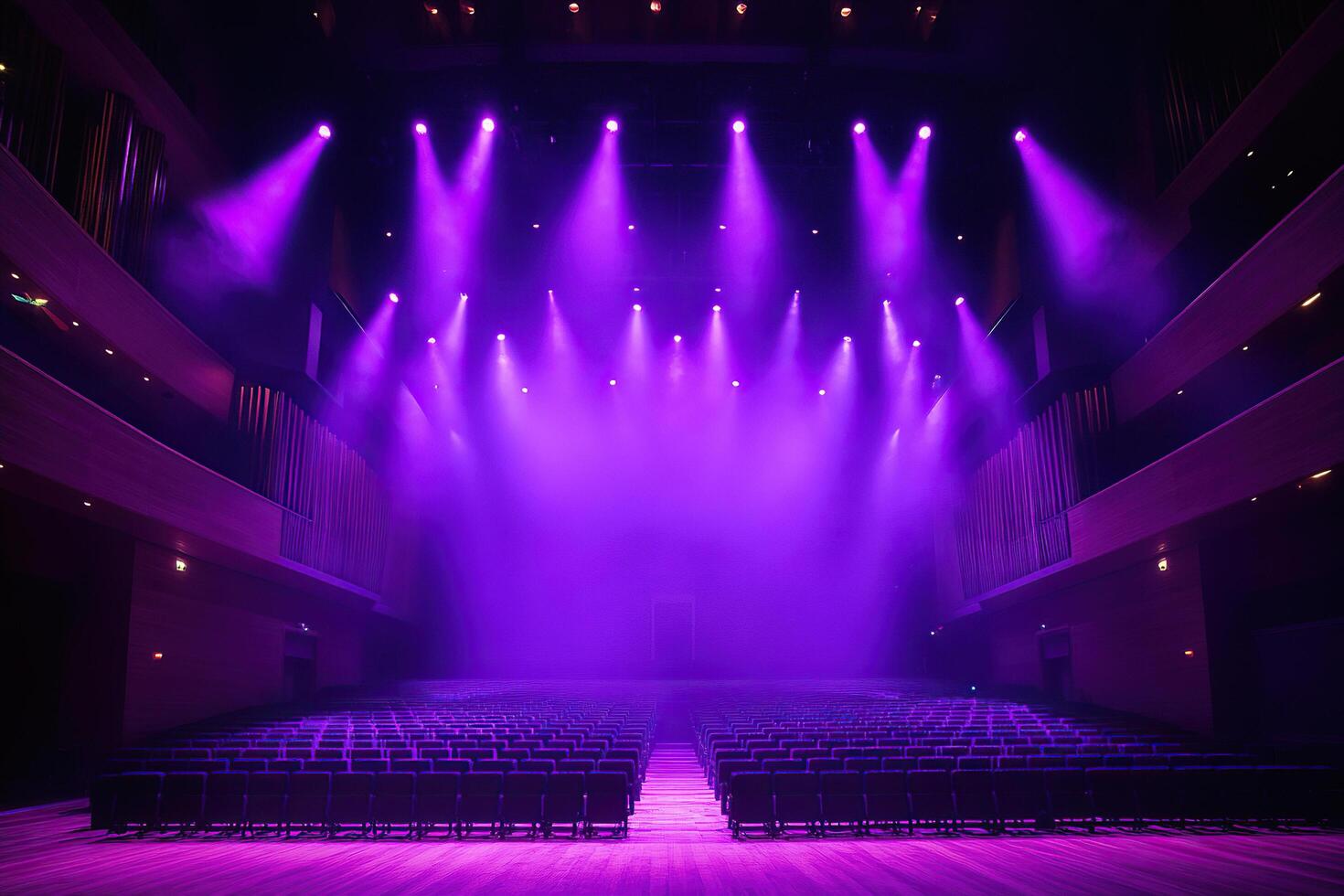 An empty concert hall with empty rows of seats illuminated by neon spotlights. photo