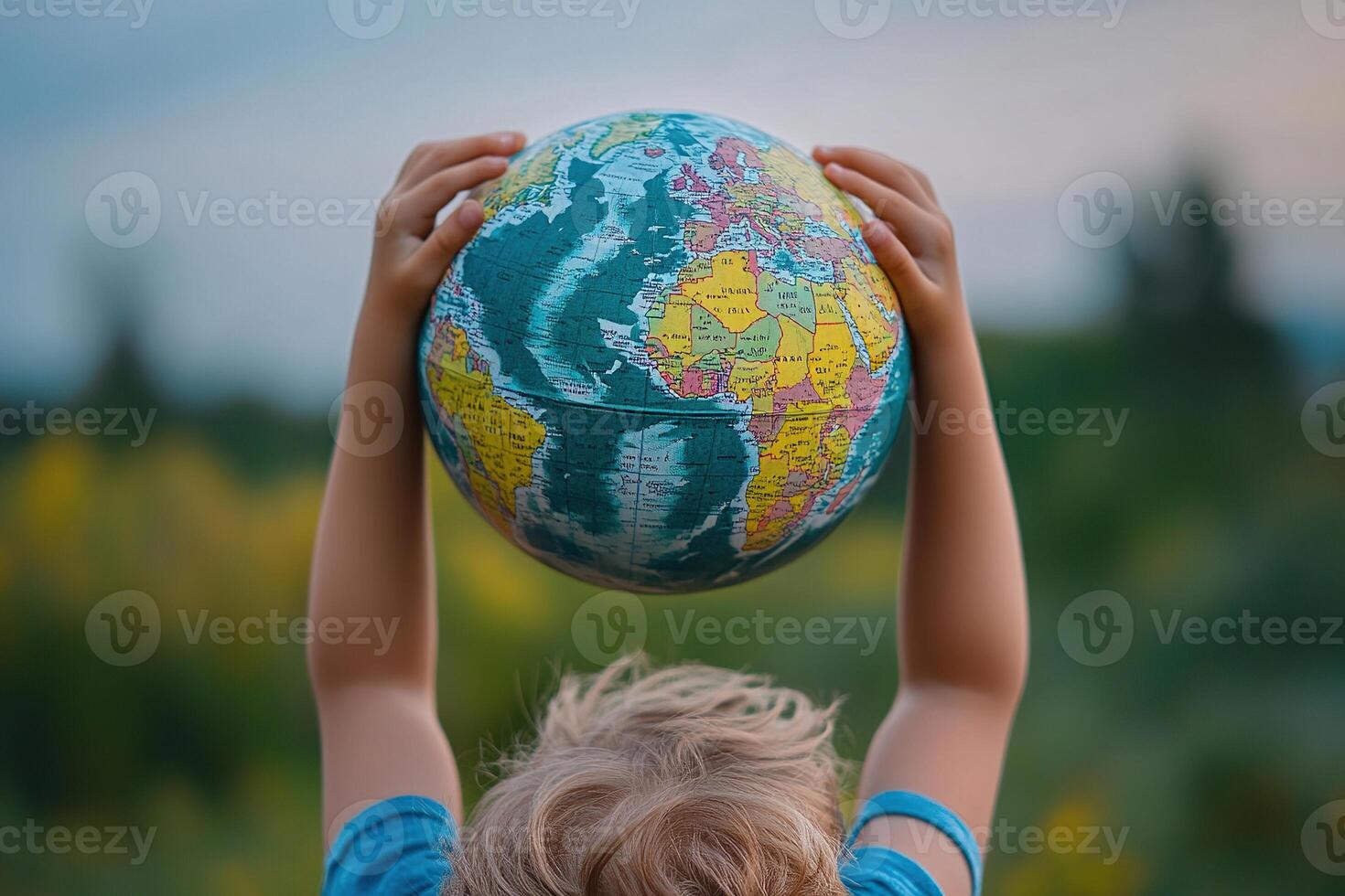 Little boy holding globe in hands on blur spring background. Earth day concept. Environmental protection photo