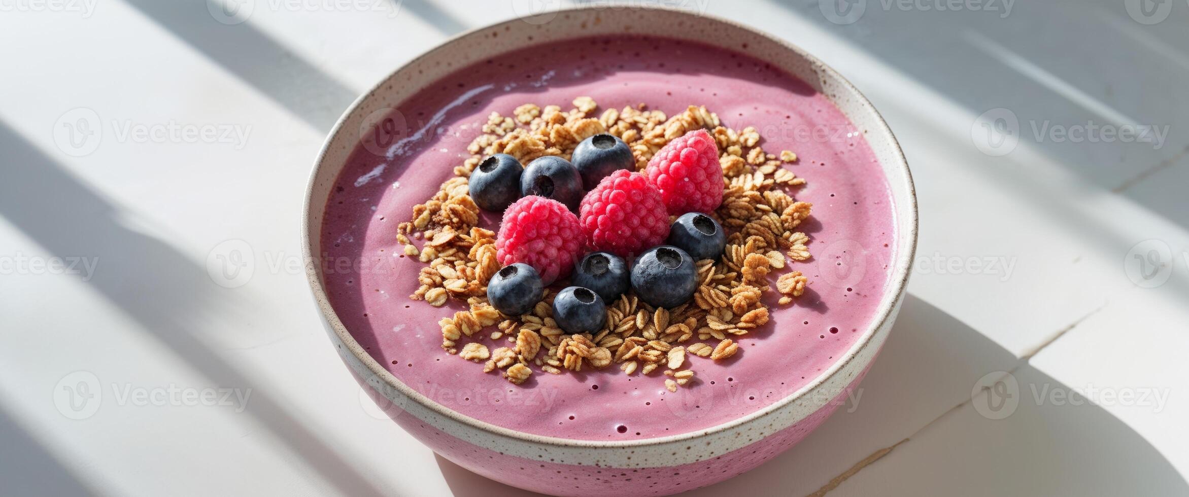 A bowl of smoothie with berries and granola photo