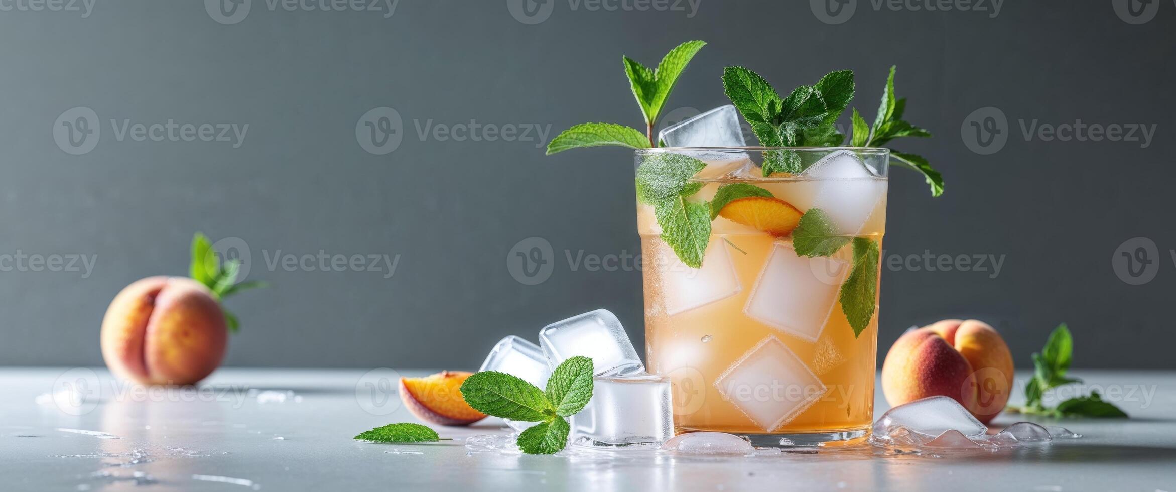 A glass of peach and mint drink with ice cubes photo