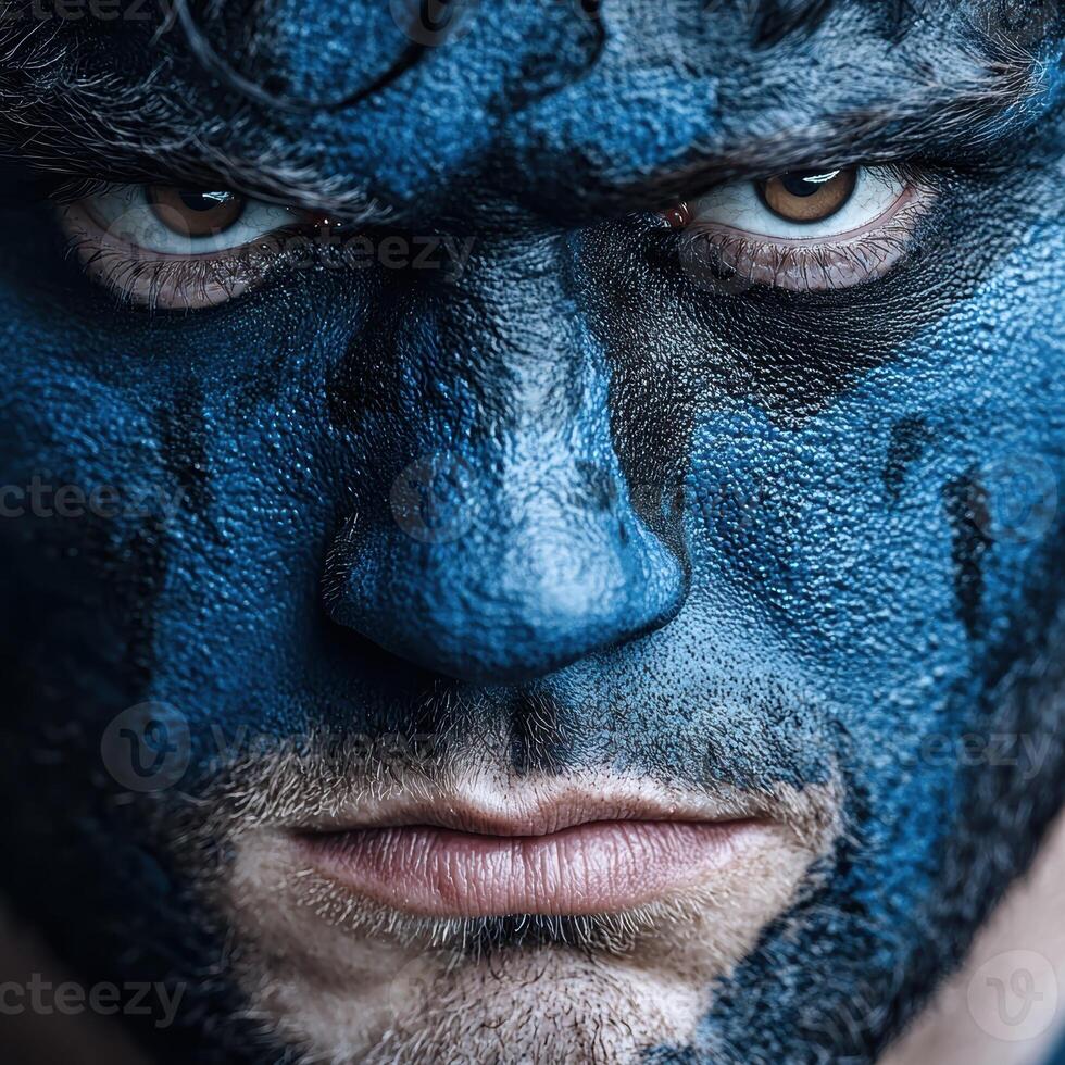 Intense portrait of a man with blue face paint photo