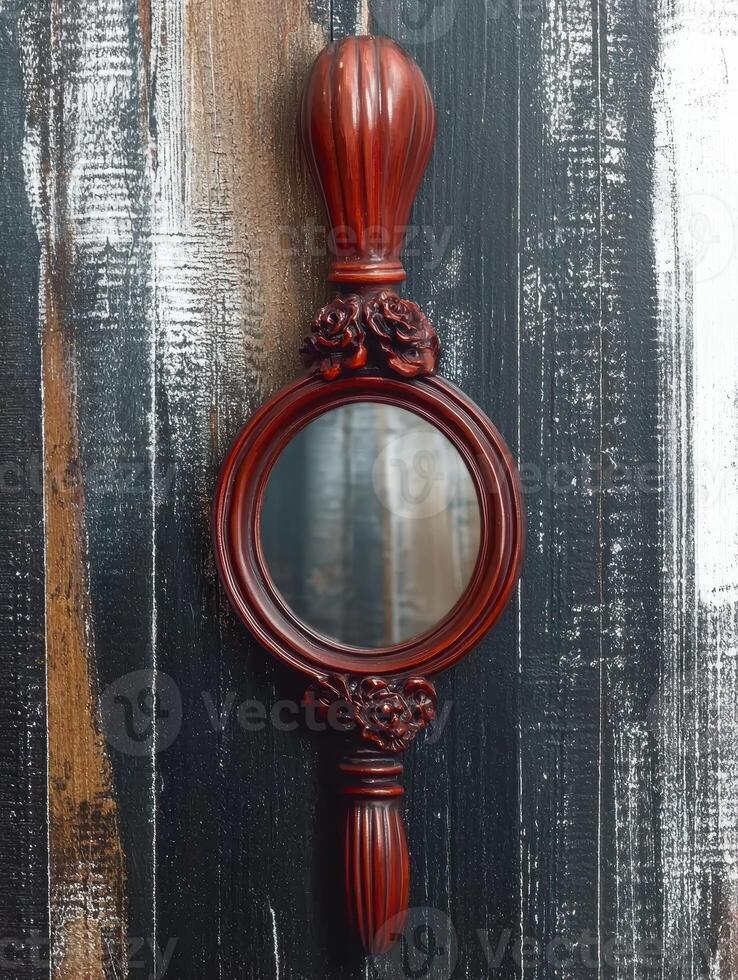 Vintage hand mirror with a wooden frame and handle photo