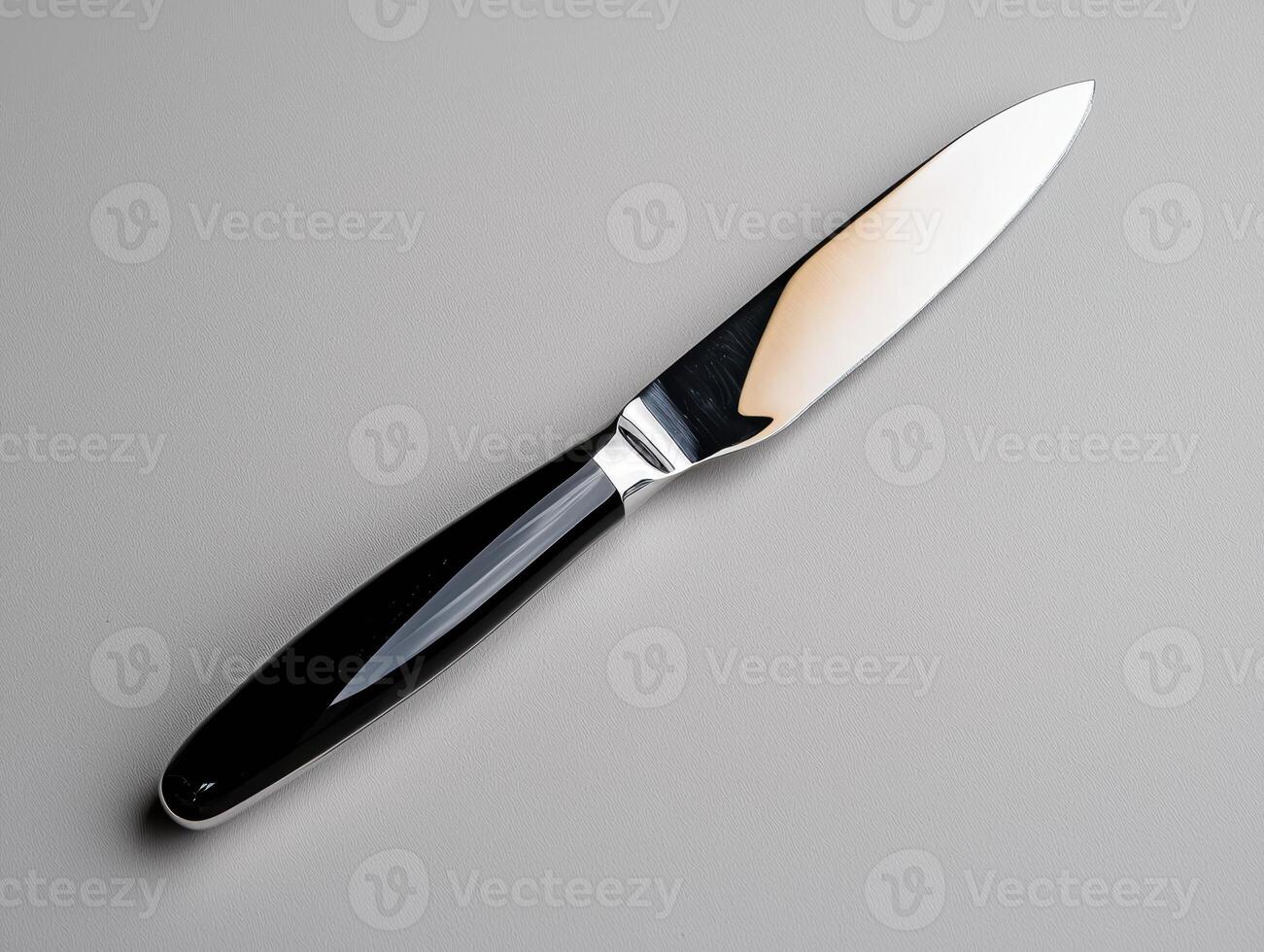 Elegant butter knife with black handle on gray background photo