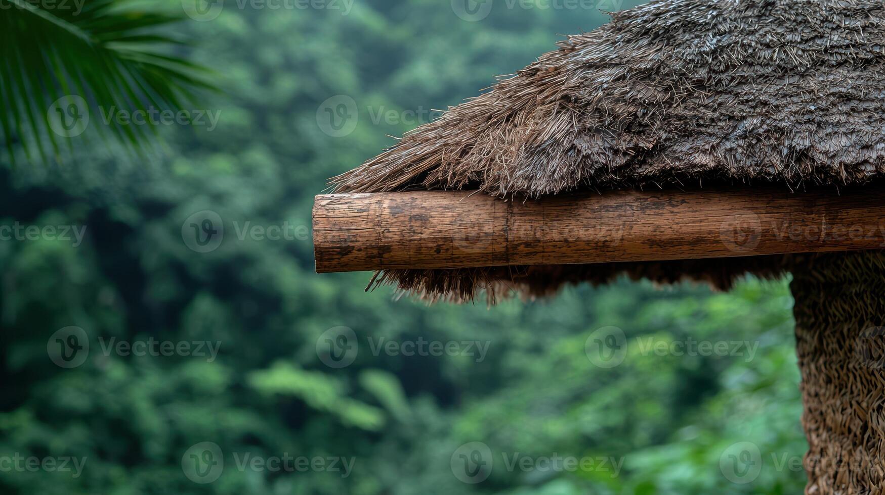 A thatched roof with a bamboo beam in a lush green environment photo