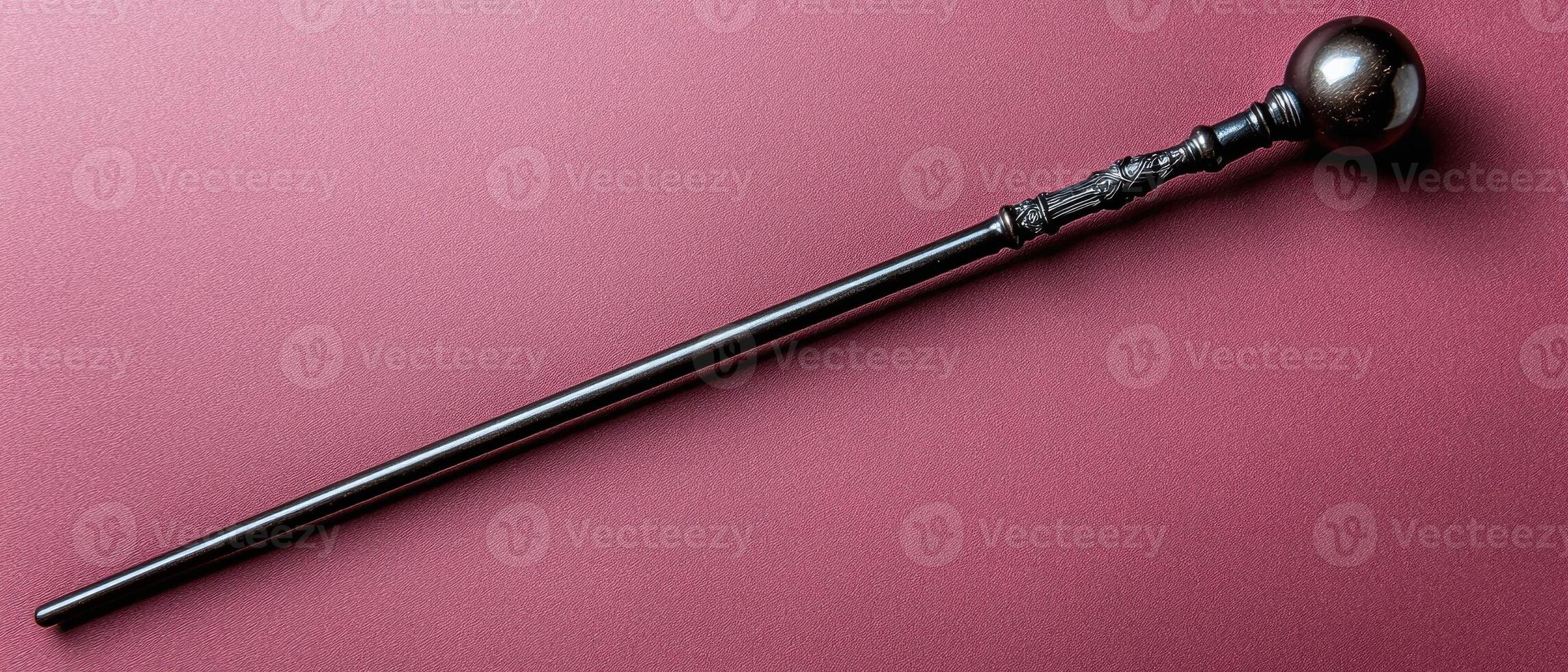 A decorative walking stick with a round handle on a pink background photo