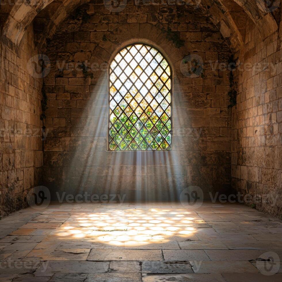 Sunlight streams through an arched window in an old stone building photo
