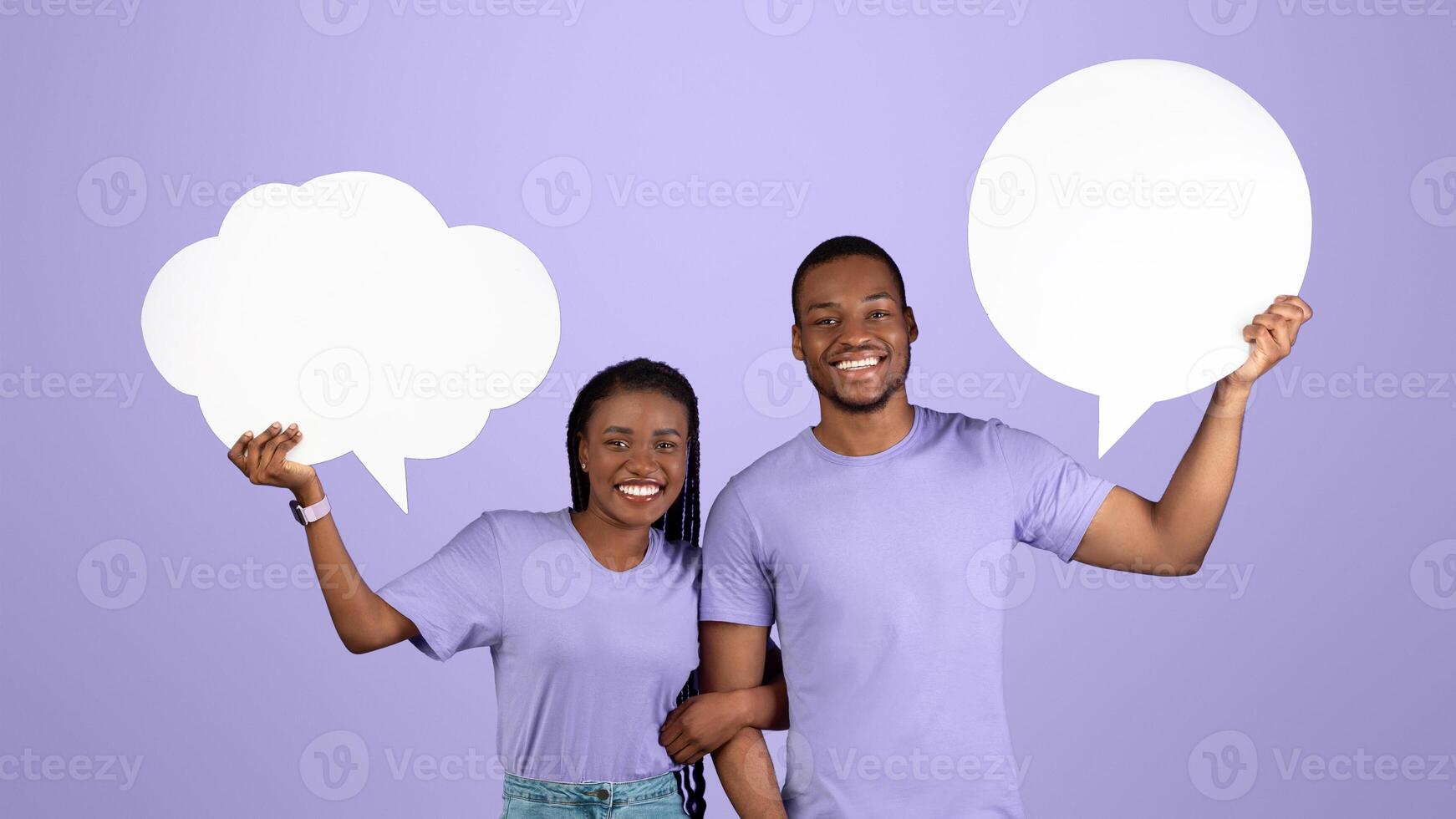 Diverse Thoughts. Smiling black couple holding empty speech bubbles with different shape, posing standing over purple violet studio background. Free empty place for text, copy space photo