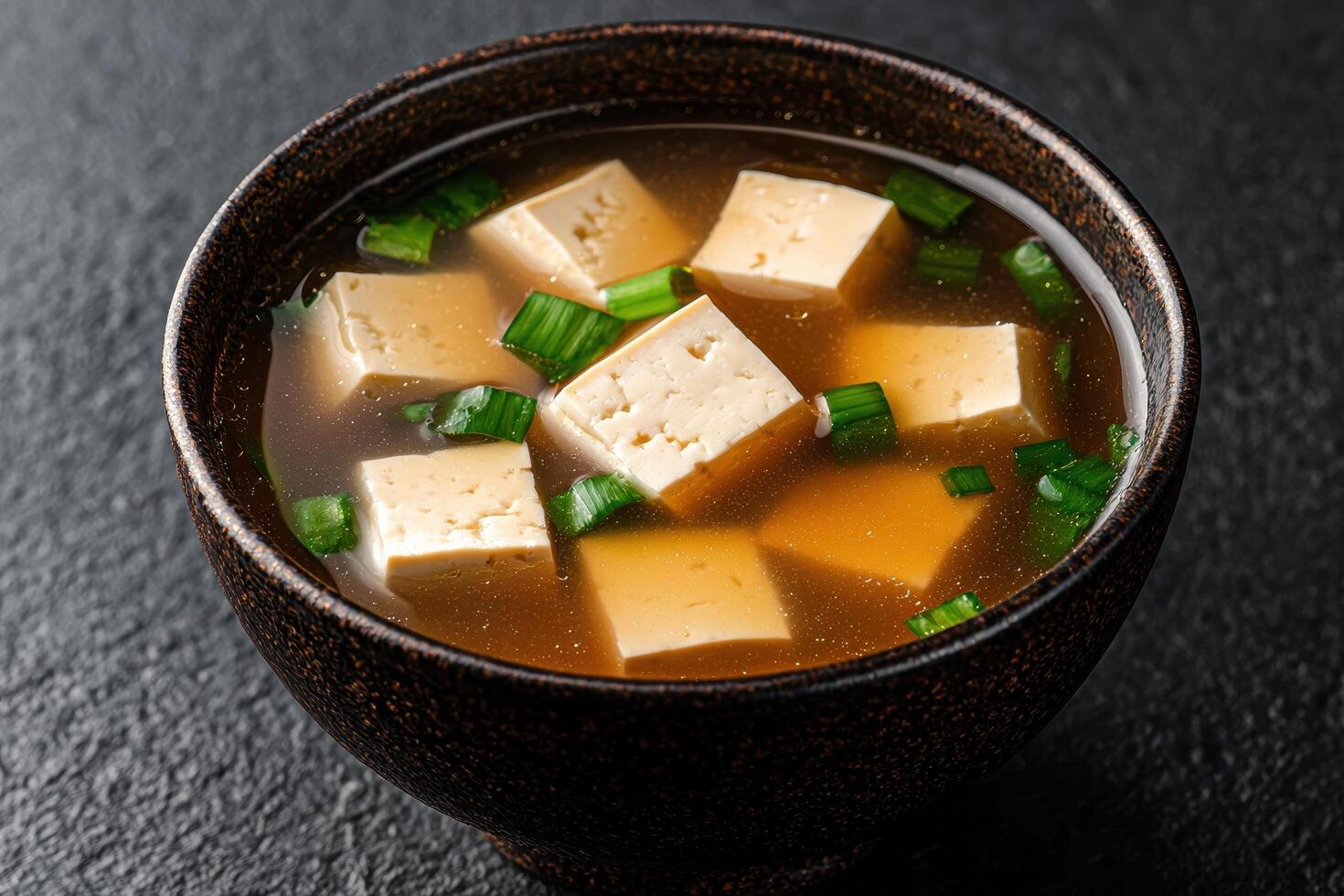 Bowl of miso soup with tofu and scallions photo