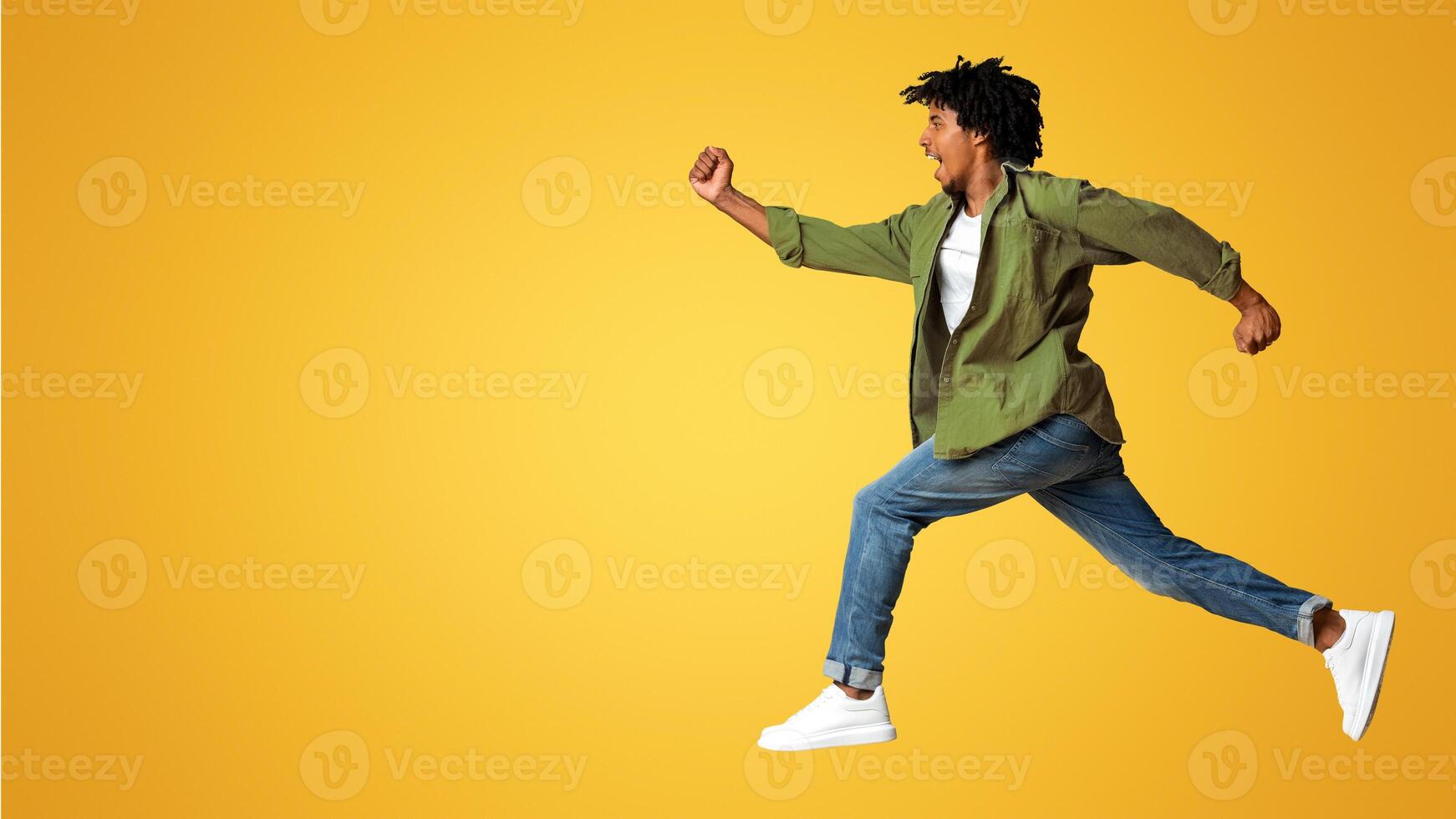 Portrait Of Young Black Guy Running Fast Over Beige Studio Background, In Motion Side View Shot Of Excited African American Man Jump In Air, Hurry Up To Sales Or Discounts, Panorama With Copy Space photo