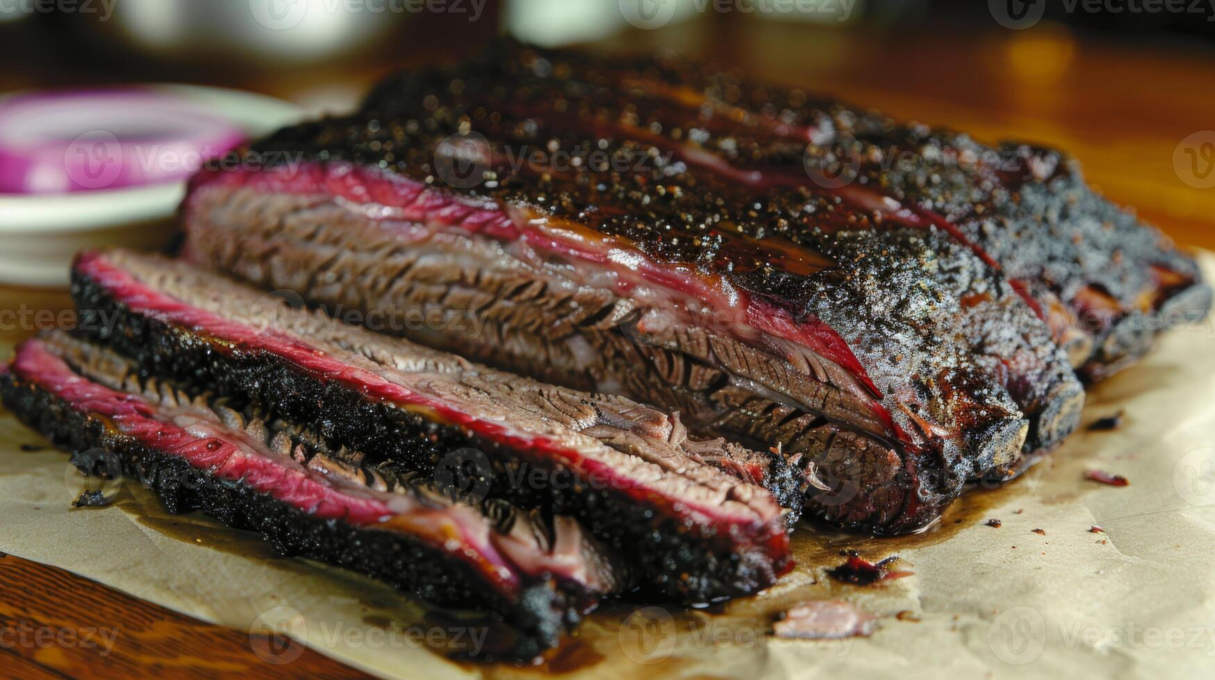 A mouthwatering display of perfectly smoked brisket, sliced into tender pieces and resting on butcher paper. Accompanied by pickles and onions, perfect for barbecue lovers. photo