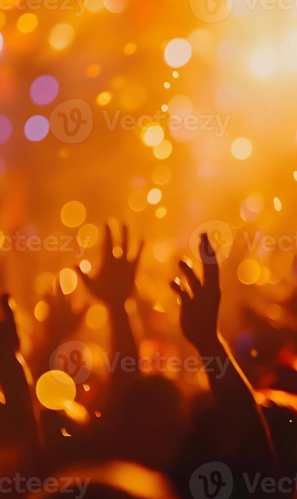 Enthusiastic crowd raising hands in vibrant concert atmosphere under golden lights photo