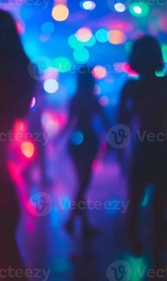 Blurred silhouettes dancing under vibrant disco lights creating a party atmosphere photo