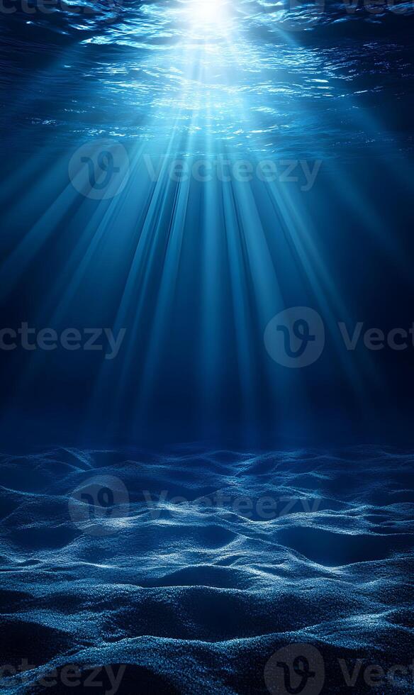 Underwater light rays illuminating sandy ocean floor creating ethereal ambience photo