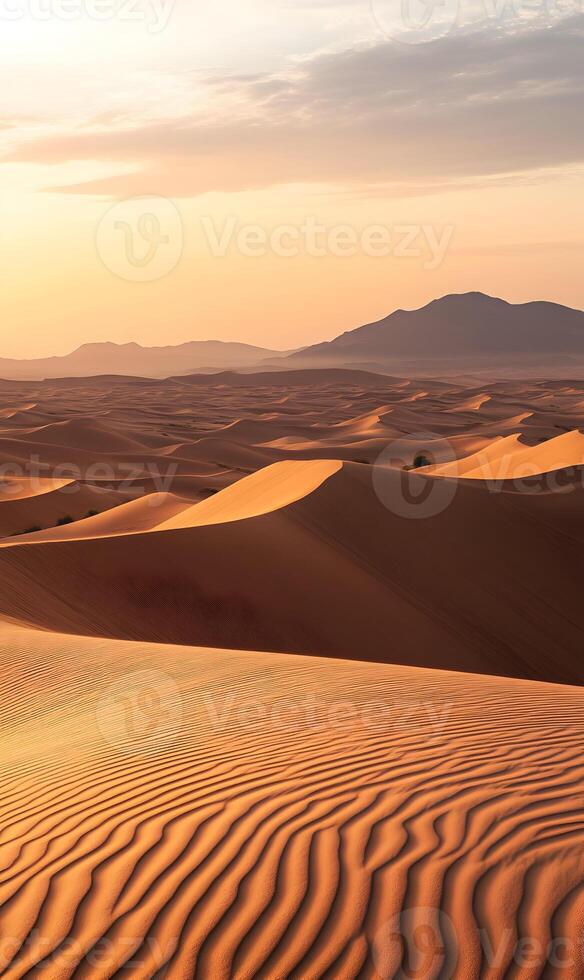 Dramatic desert landscape with rolling dunes and distant mountains at golden hour light photo