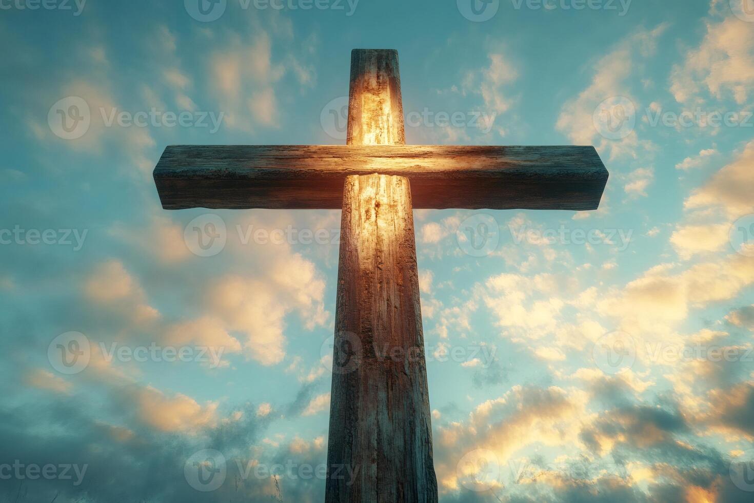 Glowing wooden cross standing tall against a dramatic cloudscape at sunset photo
