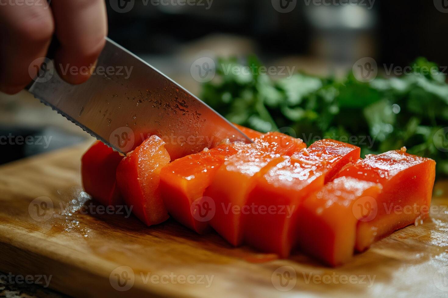 Chef cutting red bell peppers on wooden board with sharp knife photo
