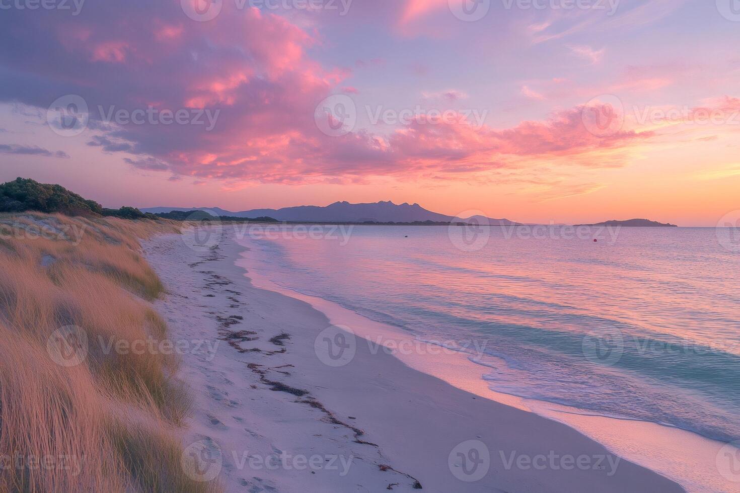 Freycinet National Park beach glows pink at sunset with The Hazards mountain range in the background photo