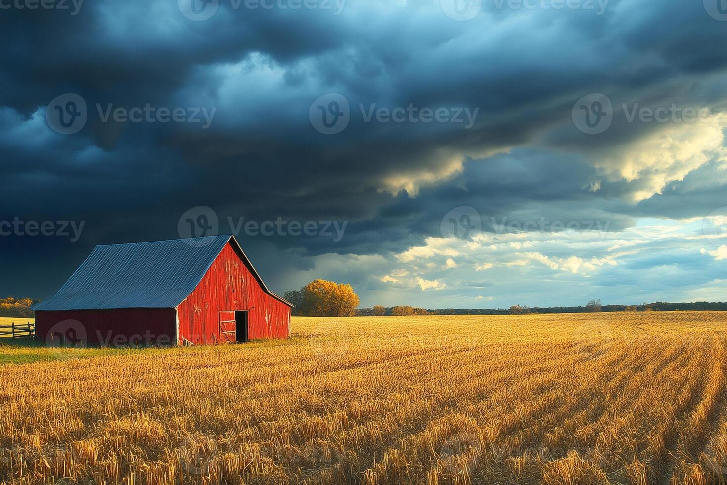 Red barn standing in harvested field under dramatic cloudy sky photo