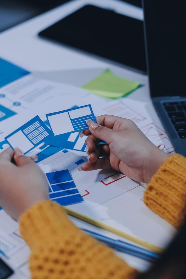 A person is working on a laptop with blue and yellow paper photo