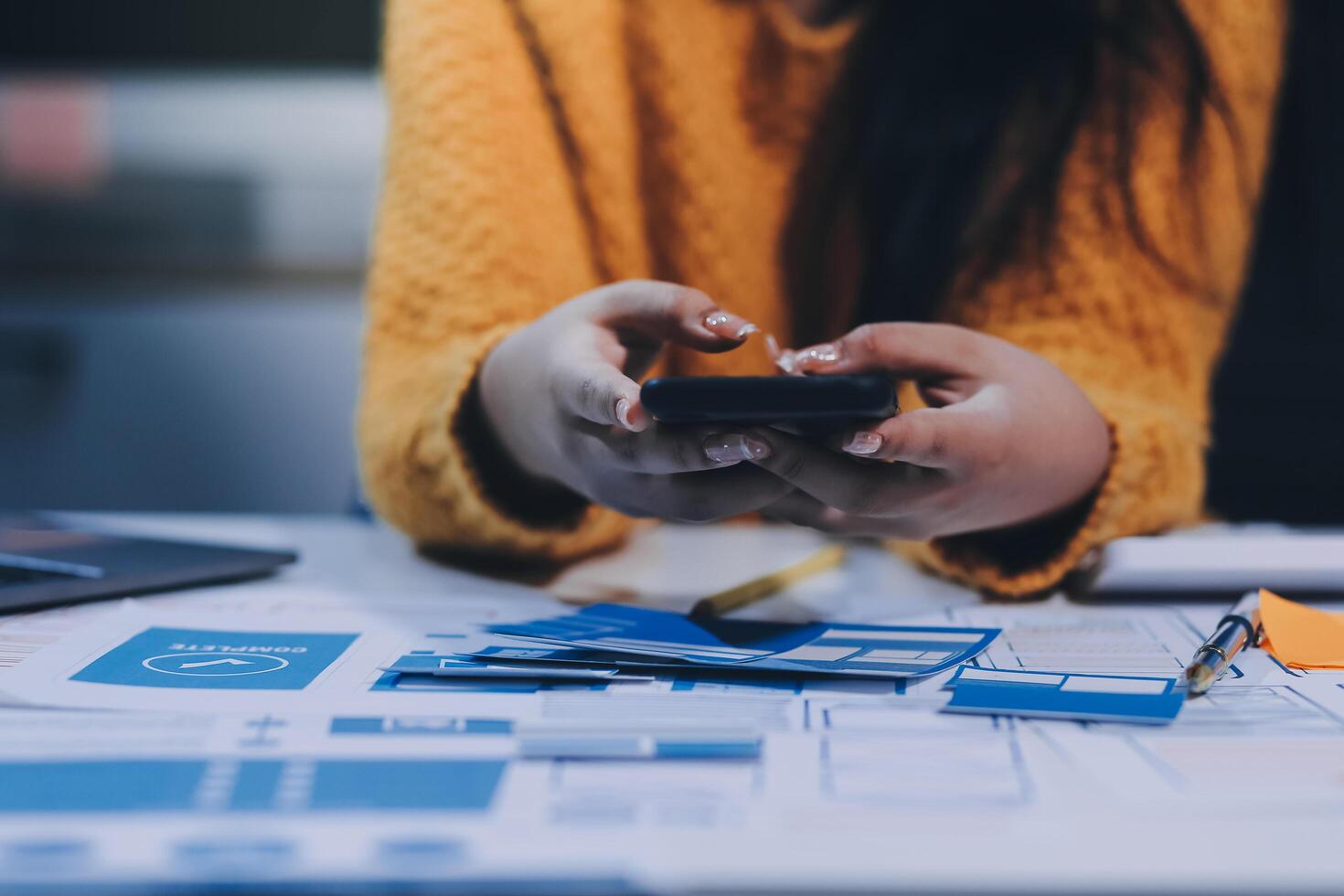 A person using a cell phone on a desk photo