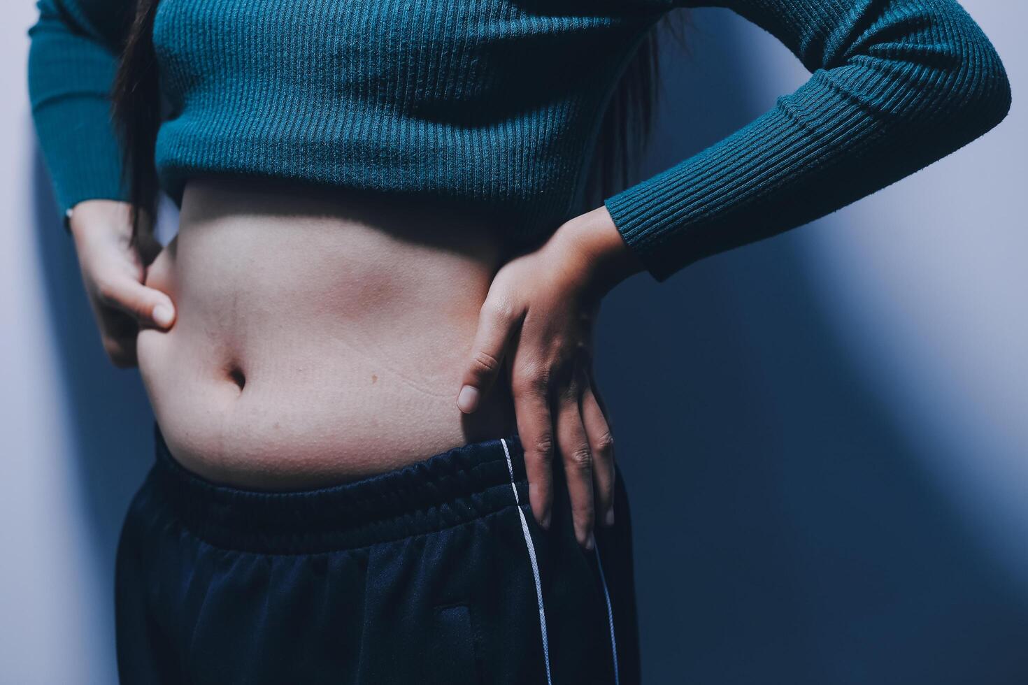 A woman with her hands on her stomach photo