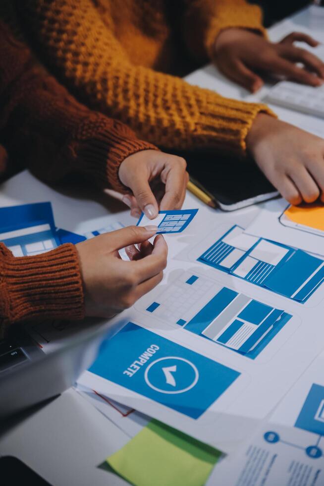 A group of people working on a project with blue and white papers photo
