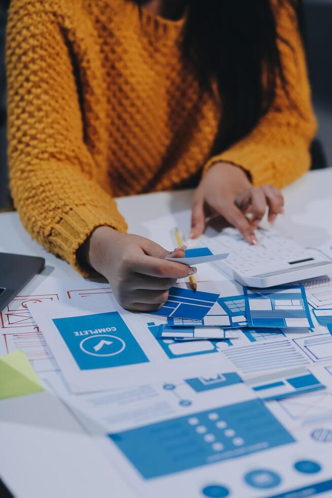 A woman is working on a project with blue and yellow papers photo