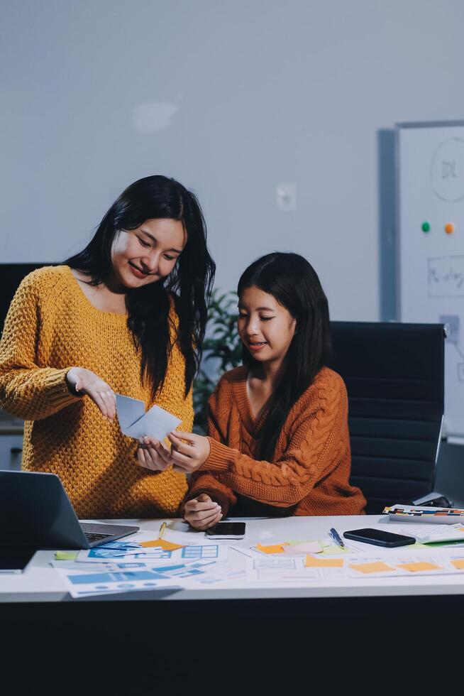 Two women working on a laptop in an office photo
