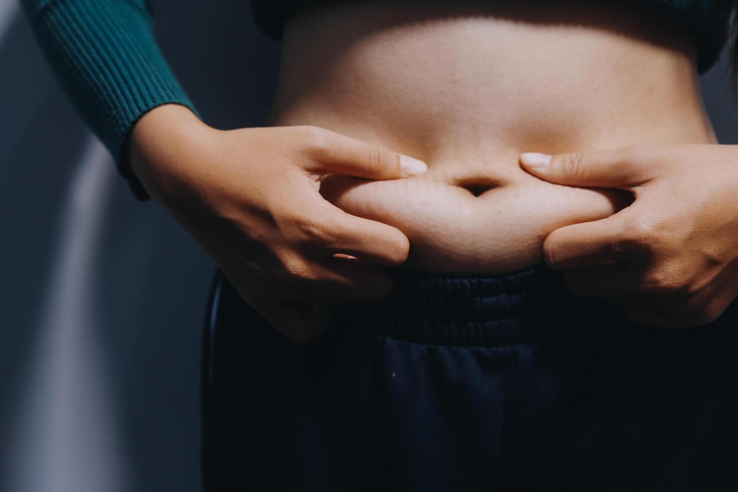 A woman is holding her stomach with her hands photo
