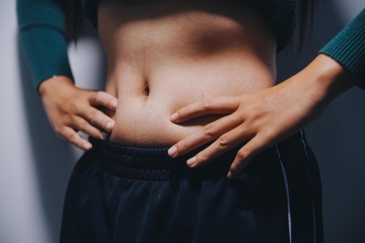 A woman with her hands on her stomach photo