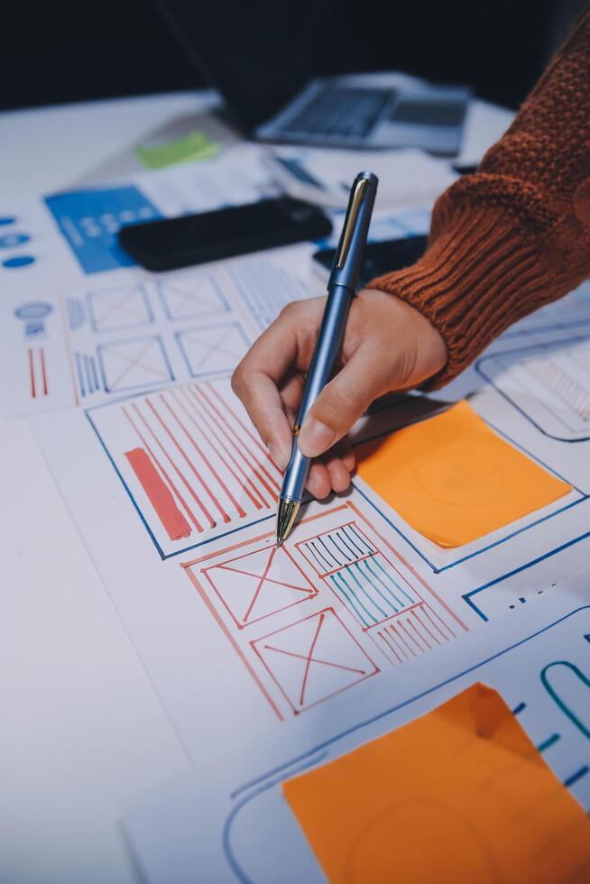 A person is writing on a piece of paper with a pen photo