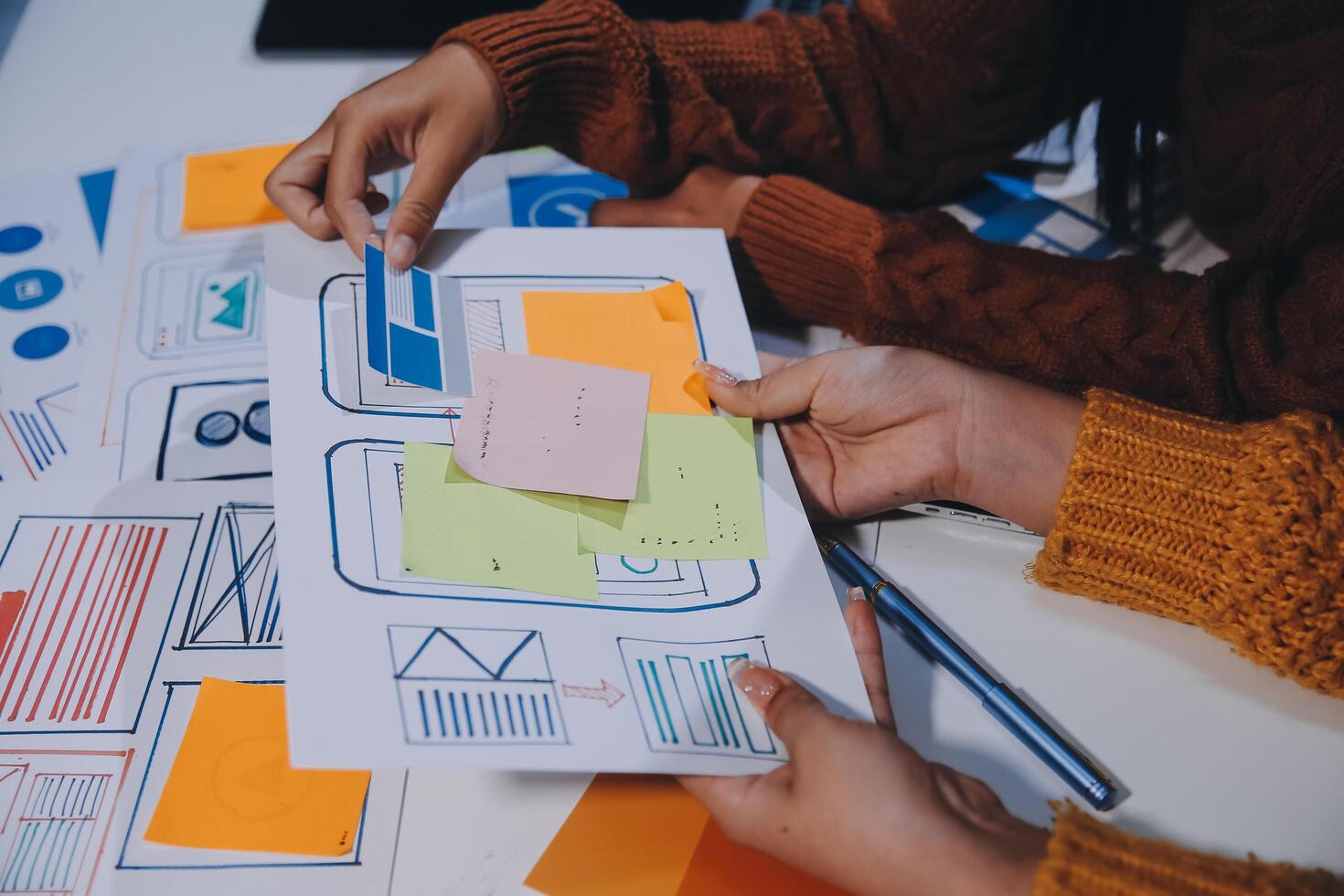 Two people working on a paper with sticky notes photo