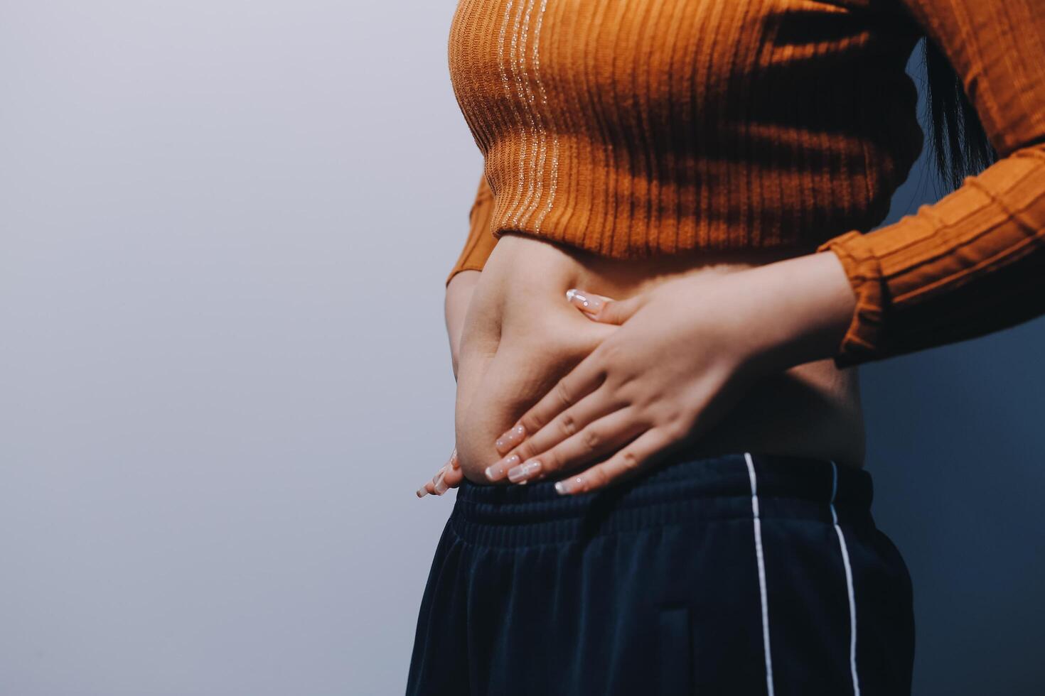 A woman with her hands on her stomach photo