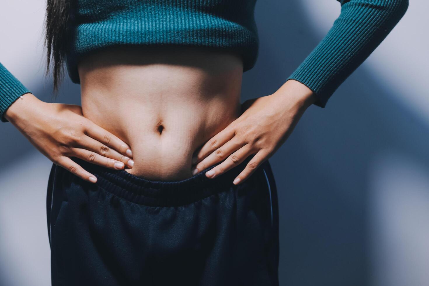 A woman with her hands on her stomach photo