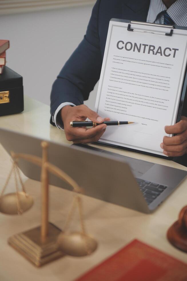 A man in a suit is signing a contract on a desk photo