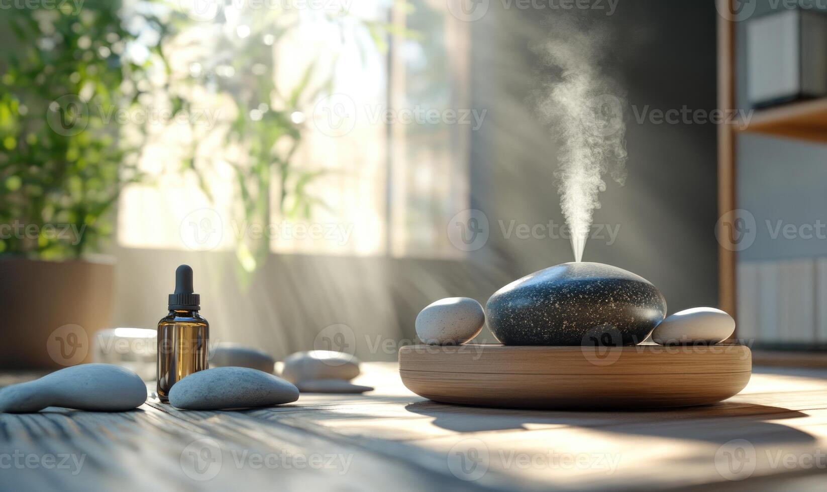 A bottle of essential oil is on a table next to a stone photo