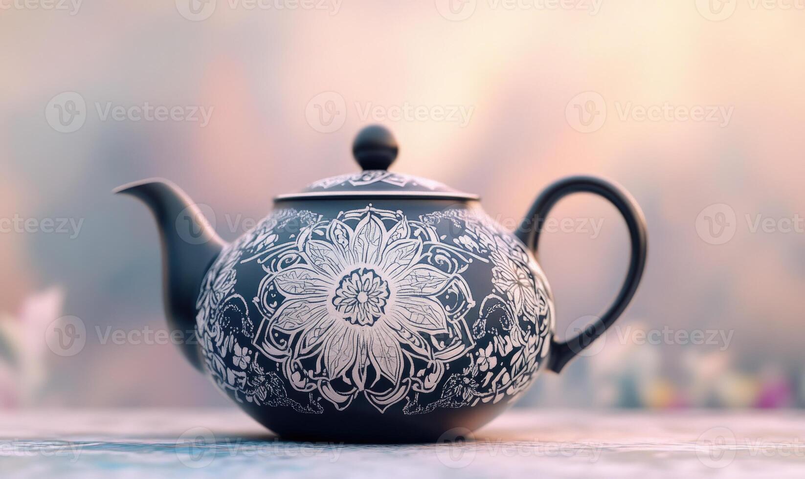 a black and white teapot with a floral design, blurred background photo