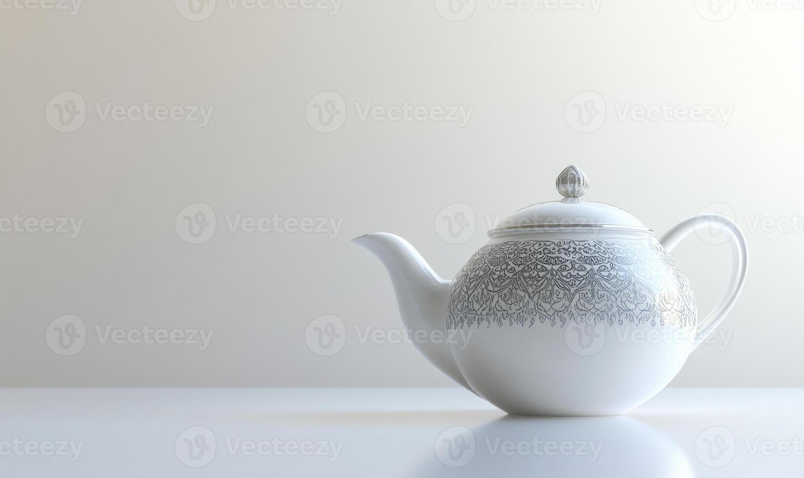 A white tea pot with a black and white design sits on a white table photo