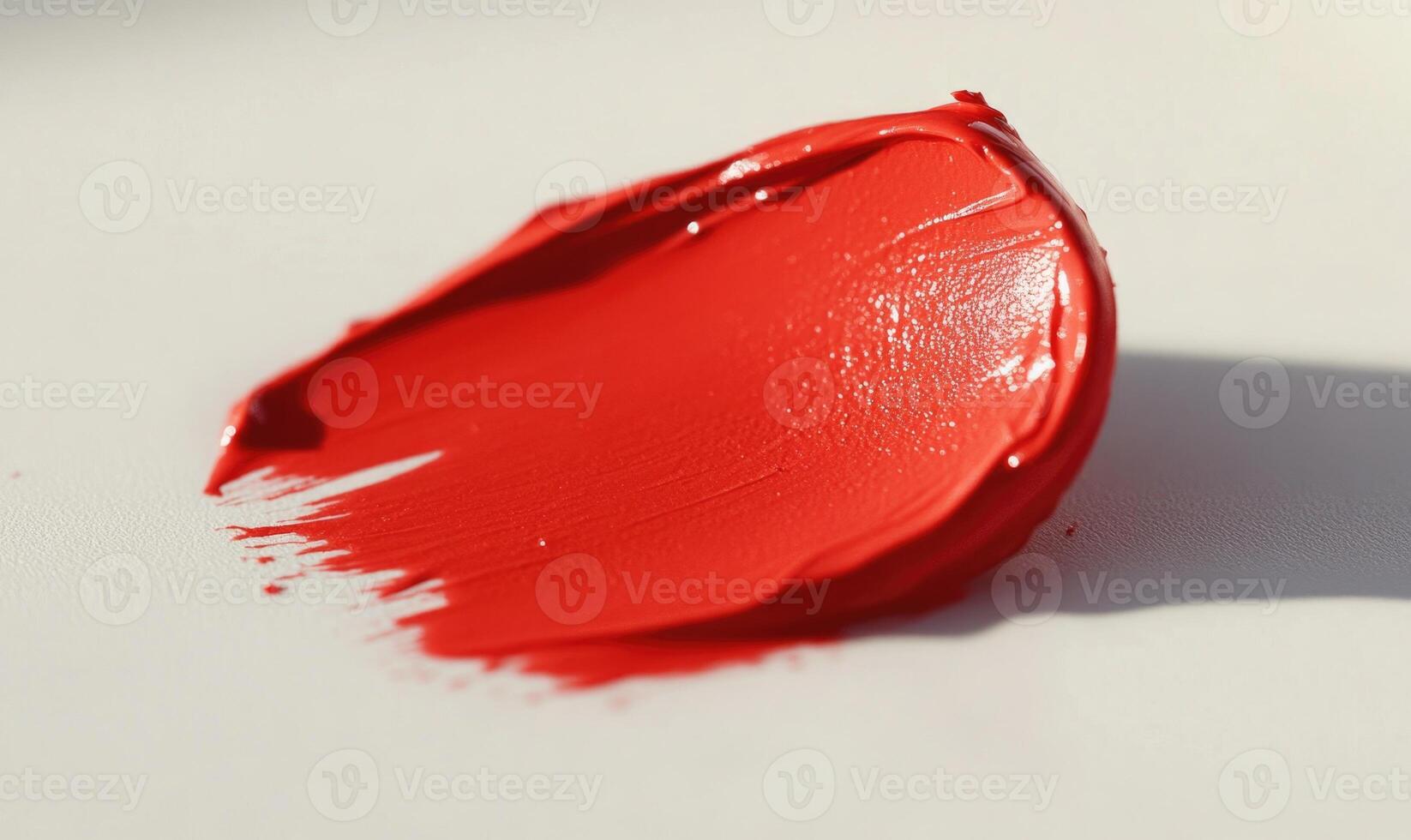 A red lipstick is on a white surface top view photo